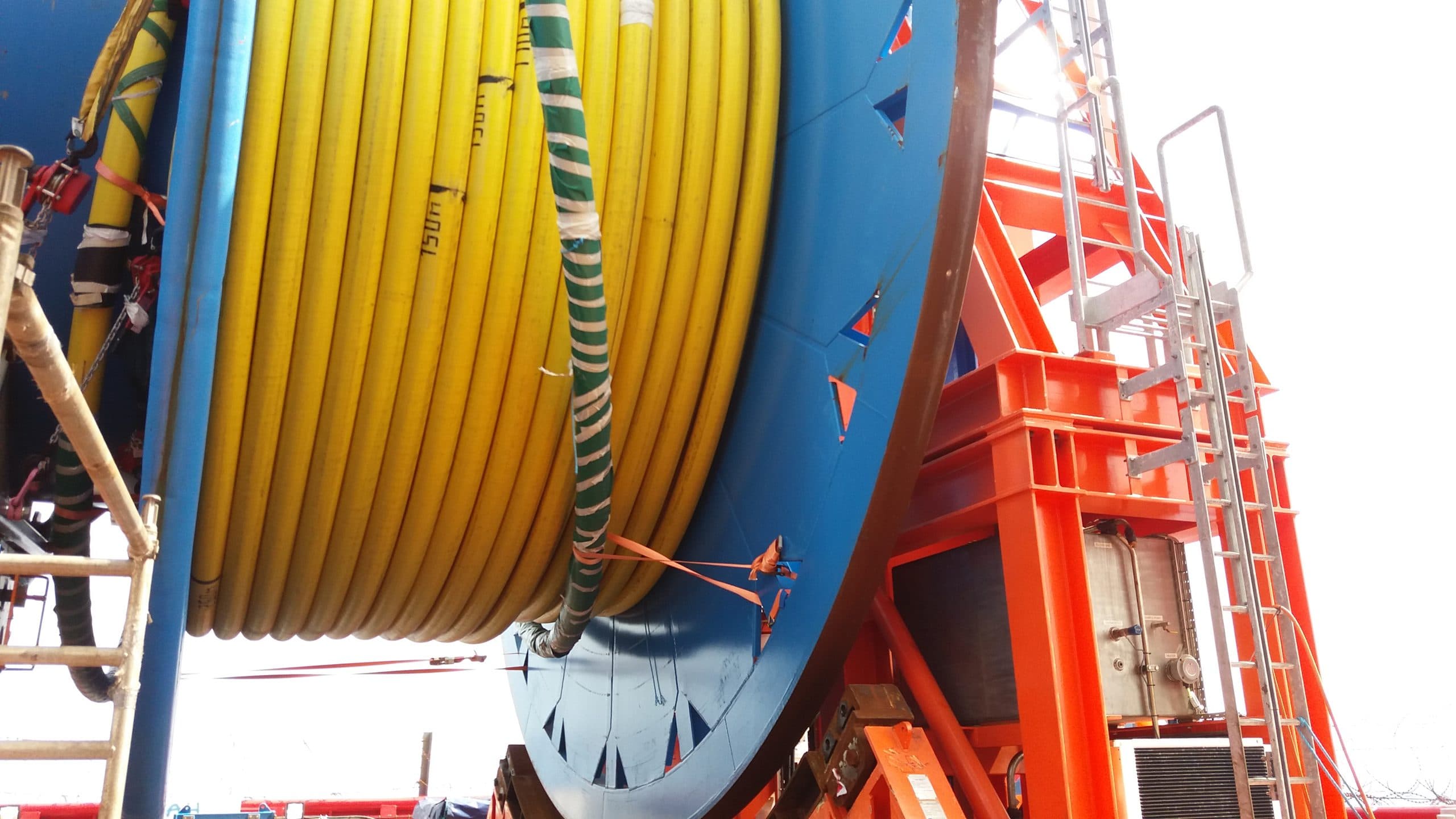 Yellow subsea umbilical spooled on an orange reel